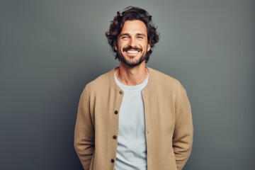 Obraz premium Portrait of a happy man in his 30s wearing a chic cardigan against a pastel gray background. AI Generation