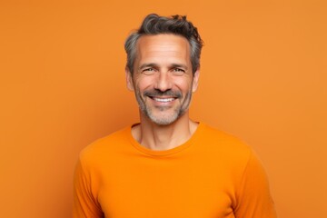 Fototapeta premium Portrait of a smiling man in his 40s donning a trendy cropped top against a soft orange background. AI Generation