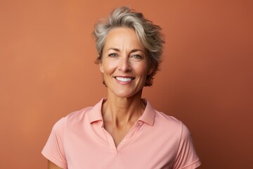 Portrait of a happy woman in her 50s wearing a sporty polo shirt against a soft brown background. AI Generation