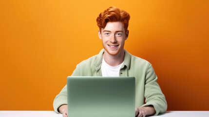 Smiling cheerful smart young ginger man wearing casual teenage clothes using laptop computer pose looking at camera isolated color background