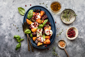A platter of roasted beets with burrata cheese, herbs and pomegranate arils.