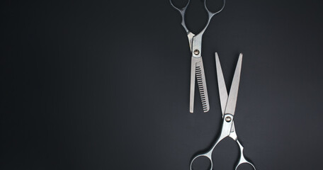 Hairdressing scissors on black background. Stylish Professional Barber Scissors. Tool care, scissor...