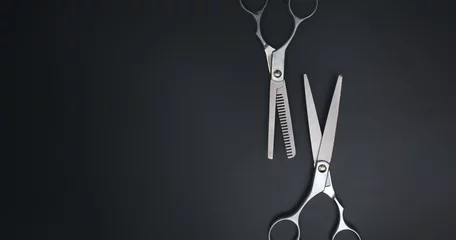 Fotobehang Hairdressing scissors on black background. Stylish Professional Barber Scissors. Tool care, scissor sharpening. © Alexa Mat