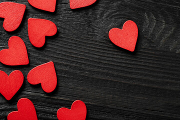 Obraz premium Red wooden hearts on black wooden background