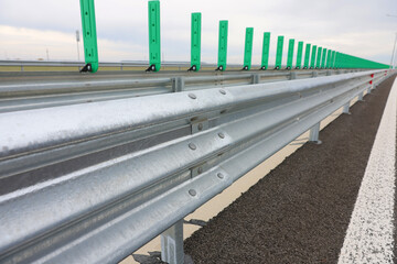 Road metal bump mounted on a new highway motorway after construction and repair in a cloudy day. Road elements mounted for safety traffic.