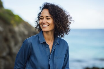 Portrait of a grinning woman in her 30s sporting a versatile denim shirt against a tranquil coral reef background. AI Generation