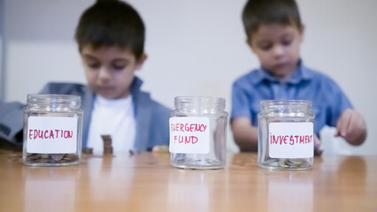 Financial education for kids. Two brothers sorting coins in the money jars. High quality photo