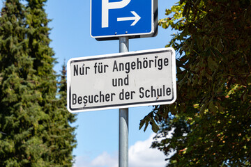 Verkehrszeichen kennzeichnet Zufahrt zu Parkplatz einer Schule