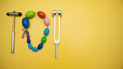 Orchidometer, Neurological Hammer and Tuning Fork C 128 on Yellow Background with Space for Text