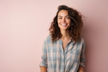 Obraz premium Portrait of a smiling woman in her 30s wearing a comfy flannel shirt against a pastel or soft colors background. AI Generation