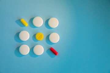 White, yellow and red tablets on a blue background