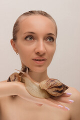 A young woman with snails on her face. Cosmetology and rejuvenation. Clear Skin