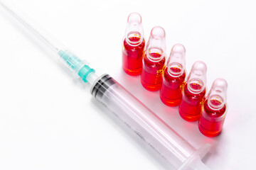 B12 hormone injection ampoules in selective focus. Ampoules and syringes containing solution for injection used for vitamin B12 supplementation. Contains cyanocobalamin.