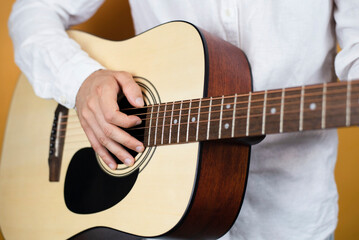 A young guy is learning to play guitar at home, he bought an online guitar and ukulele course and now he is learning play by himself, the guy has a new hobby that calms him down