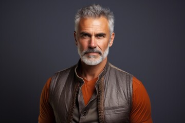 Obraz premium Portrait of a content man in his 50s dressed in a breathable mesh vest against a solid color backdrop. AI Generation
