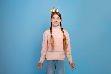 Little surprised girl with golden crown on blue background.