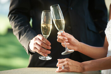 Hands, couple and toast with champagne, marriage and celebration or event. Newlyweds, people and...