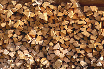 Woodpile. Background of stacked chopped logs. Firewood pile stacked chopped wood trunks for winter heating fireplace