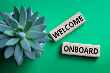 Welcome onboard symbol. Concept words Welcome onboard on wooden blocks. Beautiful green background...