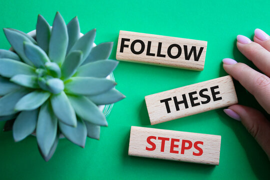 Follow these steps symbol. Wooden blocks with words Follow these steps. Beautiful green background with succulent plant. Businessman hand. Business and Follow these steps concept. Copy space.