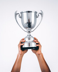 person holding a silver trophy in their two hands on a white background, concept of success