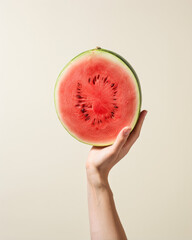 hand holding a slice of watermelon, funny banner concept with organic food isolated on a neutral background 