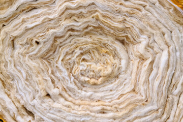 A roll of new twisted glass wool, a soft material for insulating walls and other structures,...