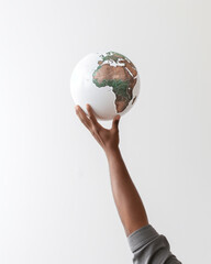 hand proudly holds the planet earth on a white background, ecology concept with white and green map