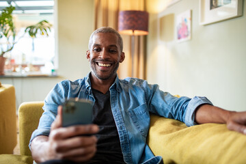 Middle aged man using the smartphone at home