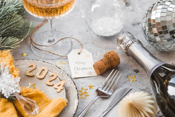 Table setting. Stylish plates, napkin, glass, champagne, Christmas tree branches and Christmas...