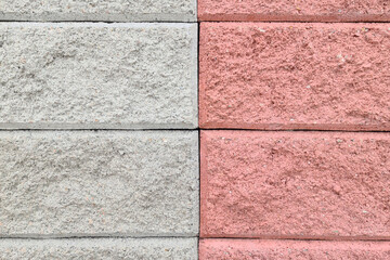 Red and gray concrete bricks on outdoor fence, background.