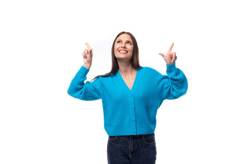 young pretty european brunette woman dressed in a blue button-down sweater actively gesturing on a white background with copy space