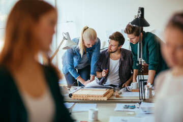 Diverse architects working on construction plans in their office