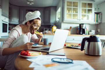 Woman with Face Mask Checking Emails Over Breakfast