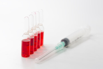 B12 hormone injection ampoules in selective focus. Ampoules and syringes containing solution for injection used for vitamin B12 supplementation. Contains cyanocobalamin.
