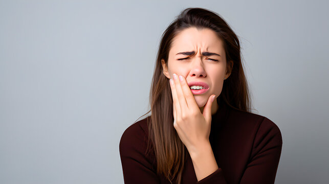 A woman with a toothache expression. Oral hygiene. Inflammation