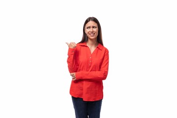 young pretty brunette secretary woman dressed in a red shirt shows her hand to the side on a white background with copy space