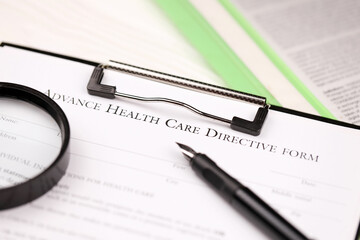 Advance health care directive blank form on A4 tablet lies on office table with pen and magnifying glass close up
