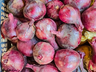 Bunch of fresh ripe onion heads lie on trading counter. Autumn agricultural fair. Texture surface background.
