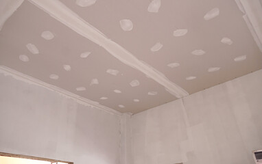 Ceiling room with plastered gypsum board smooths the walls with putty, Preparation before color paint, construction background. Home improvement, renovation concept.