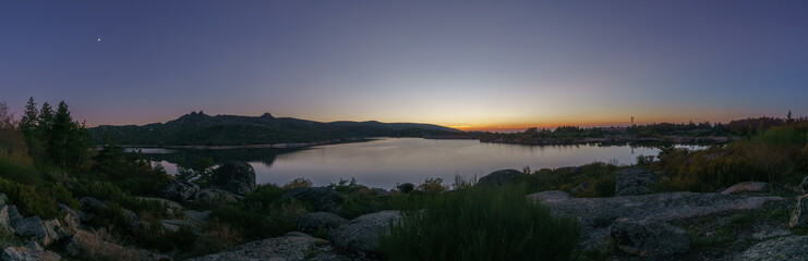 Panorama of evening twilight with Crescent moon over mountain lake after sunset in rocky pure landscape, Vale do Rossim, Serra da Estrela, Portugal