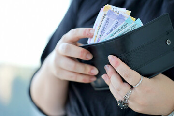 Woman hand with indian rupees bills close up. Concept of financial operations in cash in India - obrazy, fototapety, plakaty