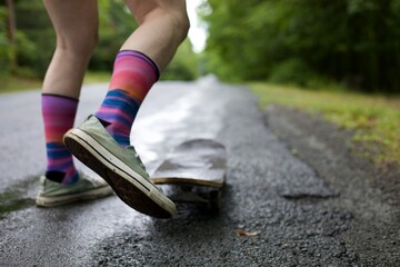 Jumping on a skateboard pointed down a long road