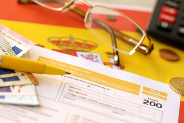 Modelo 200 spanish tax form for corporate income tax for non resident taxpayer lies on flag of Spain close up on accountant table