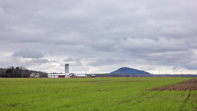Cloudy sky over a farm in the Eastern Townships with Mont St-Grégoire in the background 