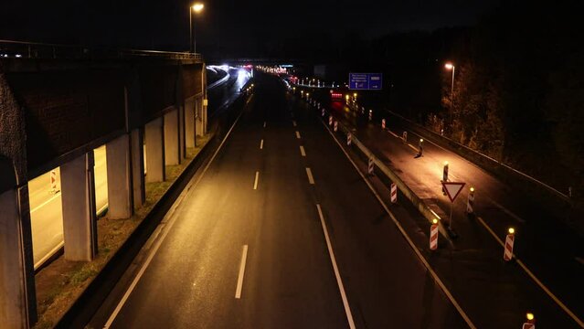 Leere Autobahn mit Baustelle und Zufahrt bei Nacht