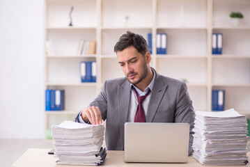 Young male employee unhappy with excessive work in the office