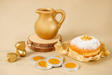 Jewish religious holiday Hanukkah with  donut, wooden dreidel (spinning top), oil jug, candles. Golden baner
