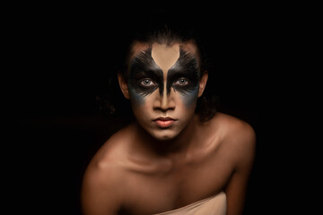 portrait of a person with face painted in black 