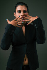 a business woman standing in black suit giving bold look depicting luxury and fashion on black background 